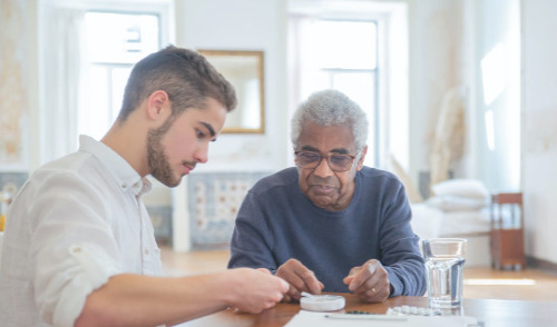 FLTCIP Enrollment Suspension - senior citizen at a table with helper