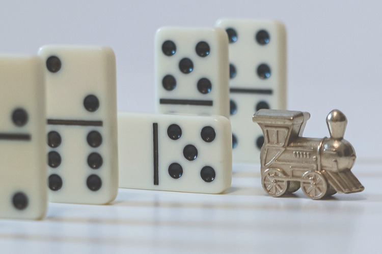 TSP Withdrawals and Rollovers are Taxed ; image: toy train amongst dominos