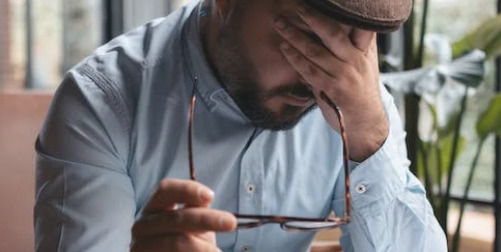 Fire Feds For Not Paying Taxes ; image: man with head in his hand, looking stressed