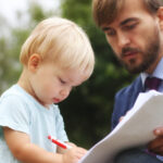 New RMD Rules, inherited IRAs ; image: man having toddler sign contract