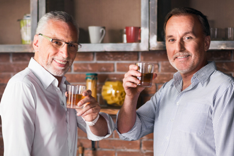 New RMD Rules ; iamge: father and adult son enjoying a drink, toasting