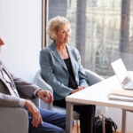 New RMD Rules ; image: older couple meeting with a professional