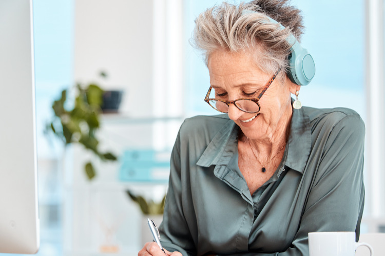 Fed15 Podcast: Health Benefits ; image: older lady at PC listening with headphones