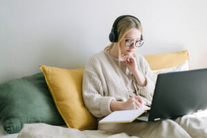 deferred retirement podcast - image: woman on laptop with headphones