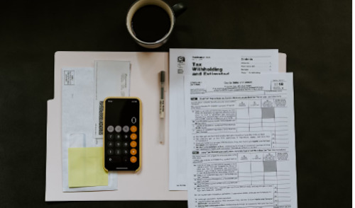 The Earnings Test ; image: cup of coffee, calculator, and tax docs