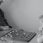 Dependent Care Flexible Spending Account ; image: grandfather playing board game with granddaughter